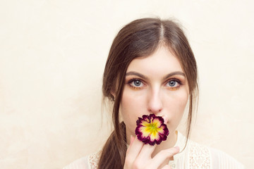 Fototapeta premium A girl holding primerose flower pretending smoking