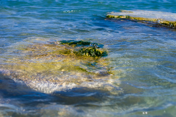 rocky sea shore with pebble beach, waves with foam