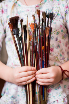 Little girl holding a brush for painting ebru technique. Hands close up