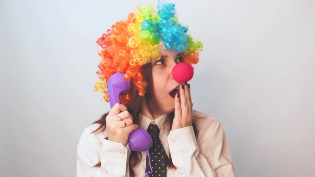 Office worker in clown wig, clown concept at work. Businessman with clown wig isolated on white. Girl Secretary in the form of a clown.