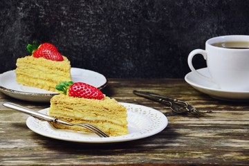 Slice of delicious cake with strawberry isolated on dark background. Copy space for your text