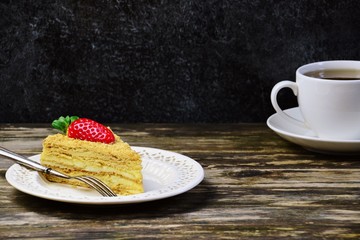 Slice of delicious cake with strawberry isolated on dark background. Copy space for your text