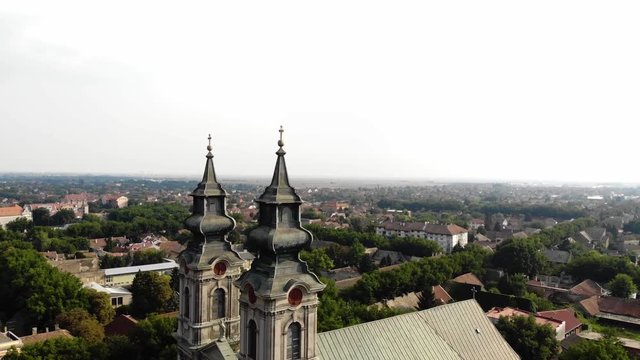 The camera turns around a catholic church, and the city behind comes visible.