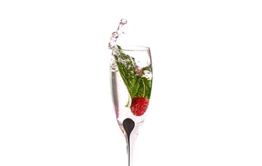 The process of falling raspberries in a glass of champagne with water