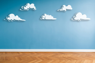 white clouds painted on blue wall in empty room  with parquet floor and copy space  -