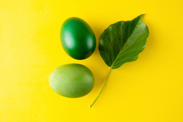 Green easter egg isolated on yellow background. Easter holiday concept. Stylish, colorful monochrome background with copy space.