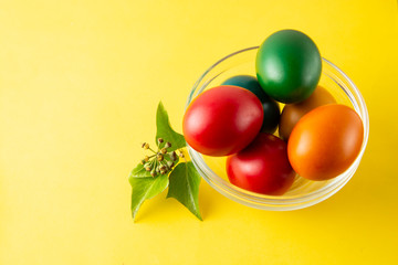 Colorful Easter eggs in bowl, easter or spring background with home painted eggs. Top view, copy space. Spring time. Colorful background.