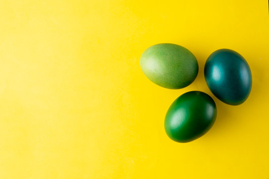 Green easter egg isolated on yellow background. Easter holiday concept. Stylish, colorful monochrome background with copy space.
