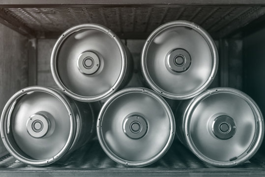 Metal beer kegs lie in a row
