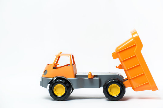  Plastic toy yellow truck on a white background. Close-up.