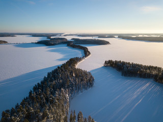 Aerial winter landscape of ridge road at frozen lake