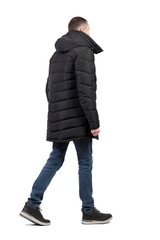 Back view of going  handsome man in jeans and winter jacket. © ghoststone