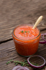  Hot tomato sauce - adjika on a wooden table