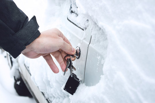 Ways to Open Frozen Car Doors. heating up the key. Male hand opening winter car door with keys, selective focus.   Opening, Warming car door lock