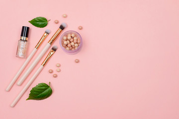 Makeup brush and cosmetics on a pink background. Background with copyspace