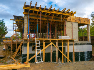 Fototapeta na wymiar Home construction. Cottage frame. Construction works. Concrete frame houses. Pouring concrete. Materials for the construction of the building. Scaffolding. Formwork