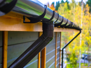 Holder gutter drainage system on the roof. Drain on the roof of the house. Roof drainage. Water drainage from the roof. - obrazy, fototapety, plakaty