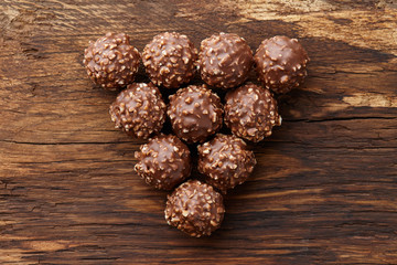 Chocolate truffle candies with hazelnuts on wood