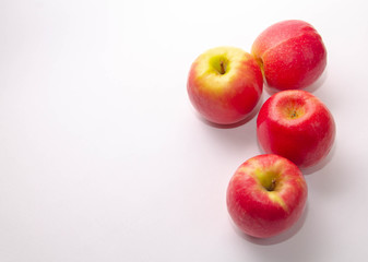 four red-yellow apples on a white background