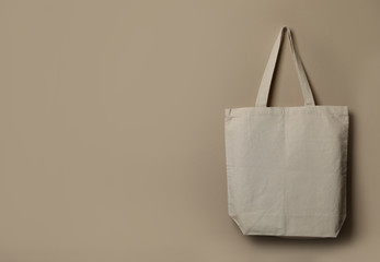 Eco tote bag hanging on color wall. Space for design