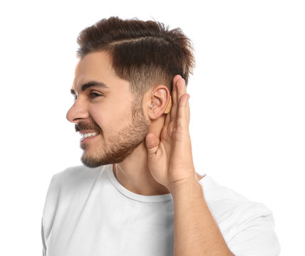 Young man with hearing aid on white background
