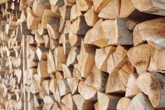 Stacked firewood as background, closeup. Heating house in winter