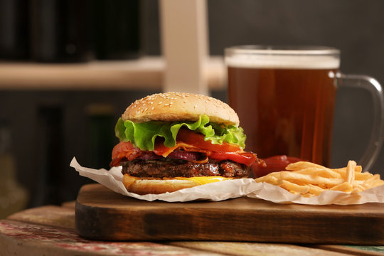 Burger, Beer And French Fries On Table Indoors