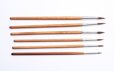 Fototapeta premium Different paint brushes on white background, top view