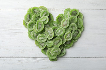 Slices of kiwi on wooden background, top view. Dried fruit as healthy food
