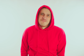 Fototapeta premium Crazy and charismatic guy posing. A man in a red tracksuit. Man isolated on white background, space for text