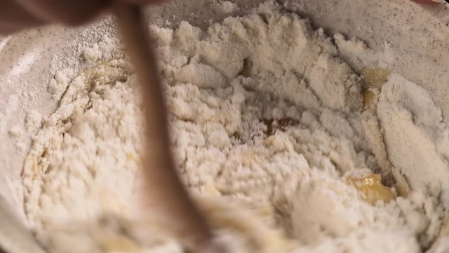 Mixing flour with eggs and sugar for making dough