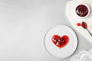 Flat lay composition with tableware, heart made of jam and space for text on light background