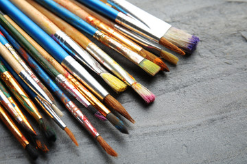 Fototapeta premium Different paint brushes on grey table, closeup