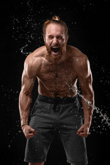 Fototapeta na wymiar Handsome young man posing with water splashes on face and chest in Studio shot