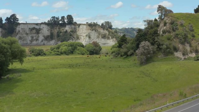 Aerial push shot over State highway and cars driving to beautiful New Zealand Rangitikei landscape.