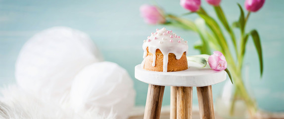 Kleiner Kuchen auf Hocker mit frühlingshaft, dekorativem Hintergrund im Banner / Header Format /...