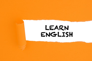 Word LEARN ENGLISH on torn paper. Concept of English language courses