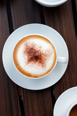 Hot coffee on wood background.