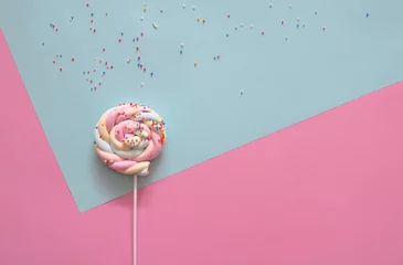 Foto op Canvas Swirl pastel lollipop on blue and pink background. © nunawwoofy