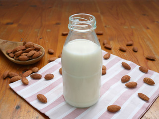 Almond milk with almond nuts on a wooden table. Vegan milk.