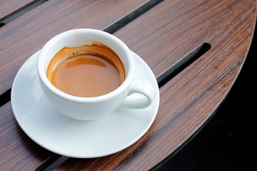 Hot coffee on wood background.