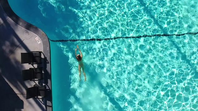 Top View Of A Naked Girl Swims In The Swimming Pool.