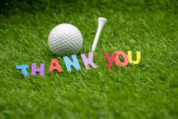 Golf ball with thank you word on green grass