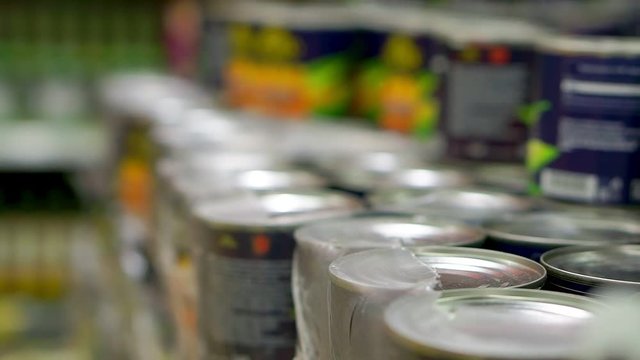 Packaging canned fruits. Stand on a shelf in the store. Selective focus