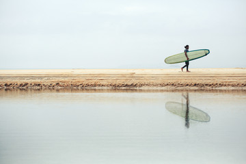 male surfer with long board on the sea silhouette