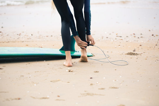 Female surfer put on leash on her leg to long board