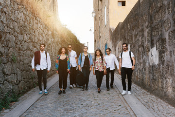 Group of young people, students, walking on city street together