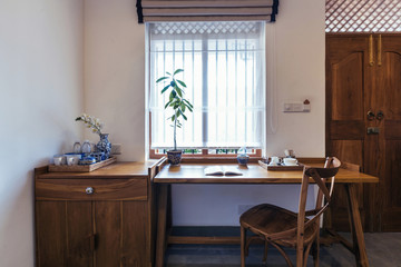 Modern hotel room interior with working space, wooden desk, chair, book and window