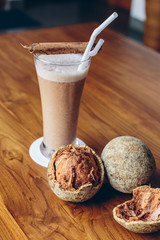 Wood apple or Limonia drink in glass on wooden table with fruits and cinnamon