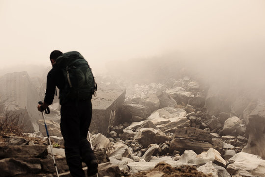 Hiker walking in foggy mountains